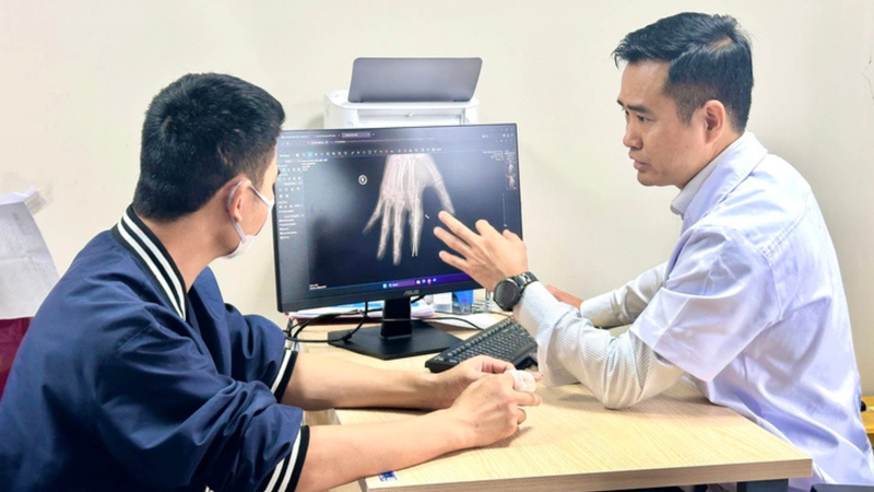 Bác sĩ trao đổi kết quả X-quang và đánh giá phục hồi ngón tay cho bệnh nhân