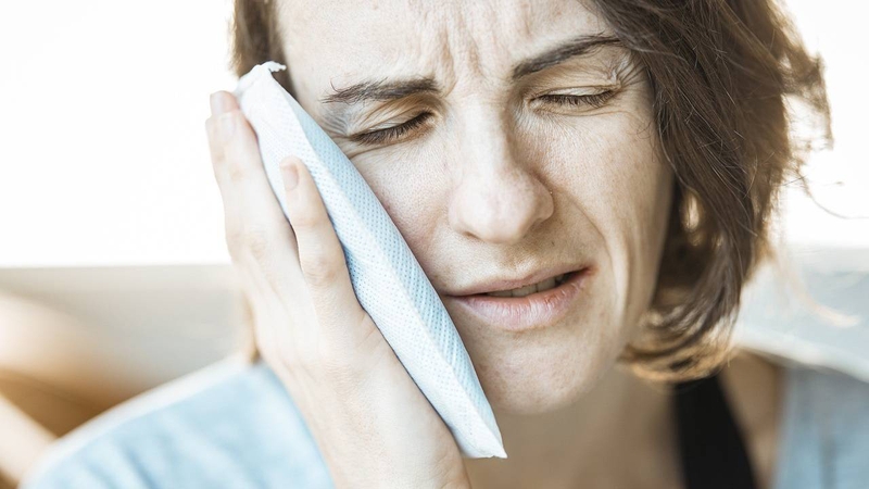 Một trong những cách giảm sưng sau khi nhổ hai răng sâu là chườm lạnh ngoài má