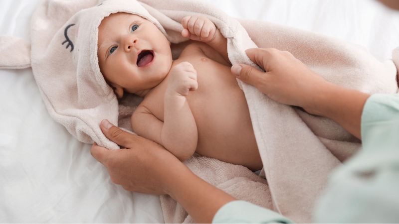 Lau khô và giữ ấm cơ thể giúp trẻ sơ sinh tránh bị nhiễm lạnh sau khi tắm