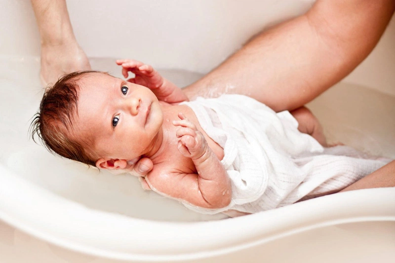 Khi tắm cho trẻ, cha mẹ không nên để cuống rốn của trẻ tiếp xúc với nước tắm, nước xà phòng