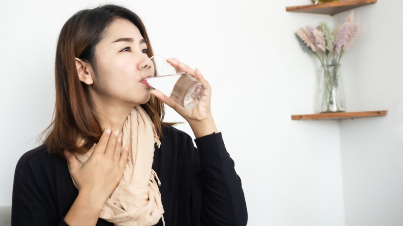 Uống nước ấm giúp giữ ẩm cổ họng và giảm cảm giác khô rát