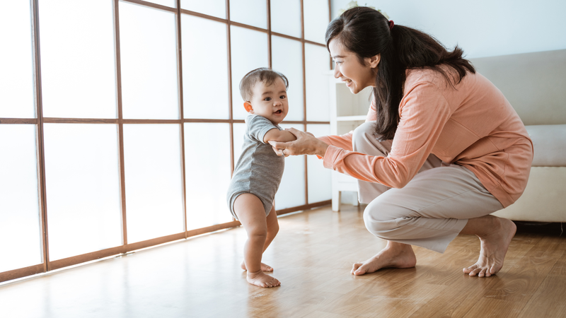 Bé có thể nắm tay bố mẹ hoặc đẩy các món đồ chơi có bánh xe để di chuyển