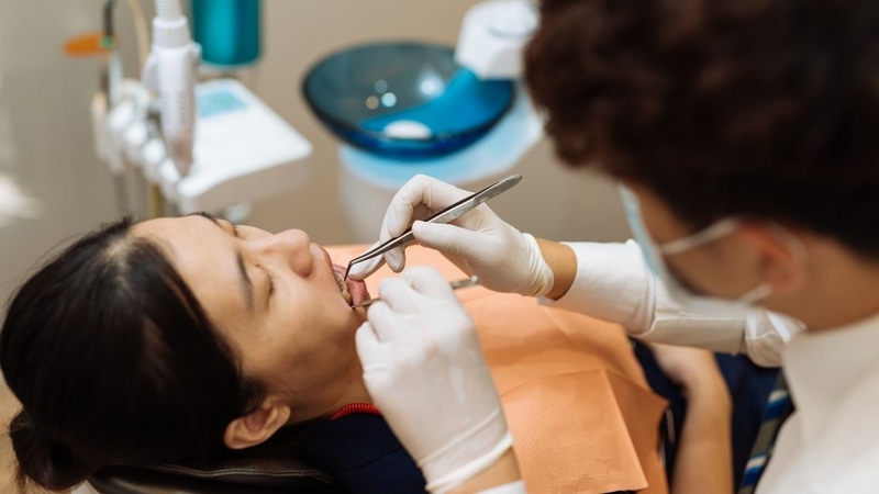 Bác sĩ thăm khám răng khôn trước khi thực hiện thủ thuật